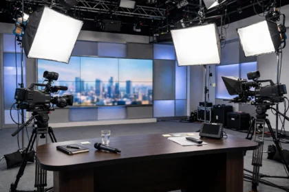 Warm television studio with soft lights and an empty presenter chair.
